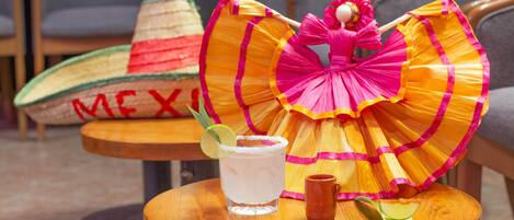 Una mesa con una bebida, una taza pequeña y un adorno.