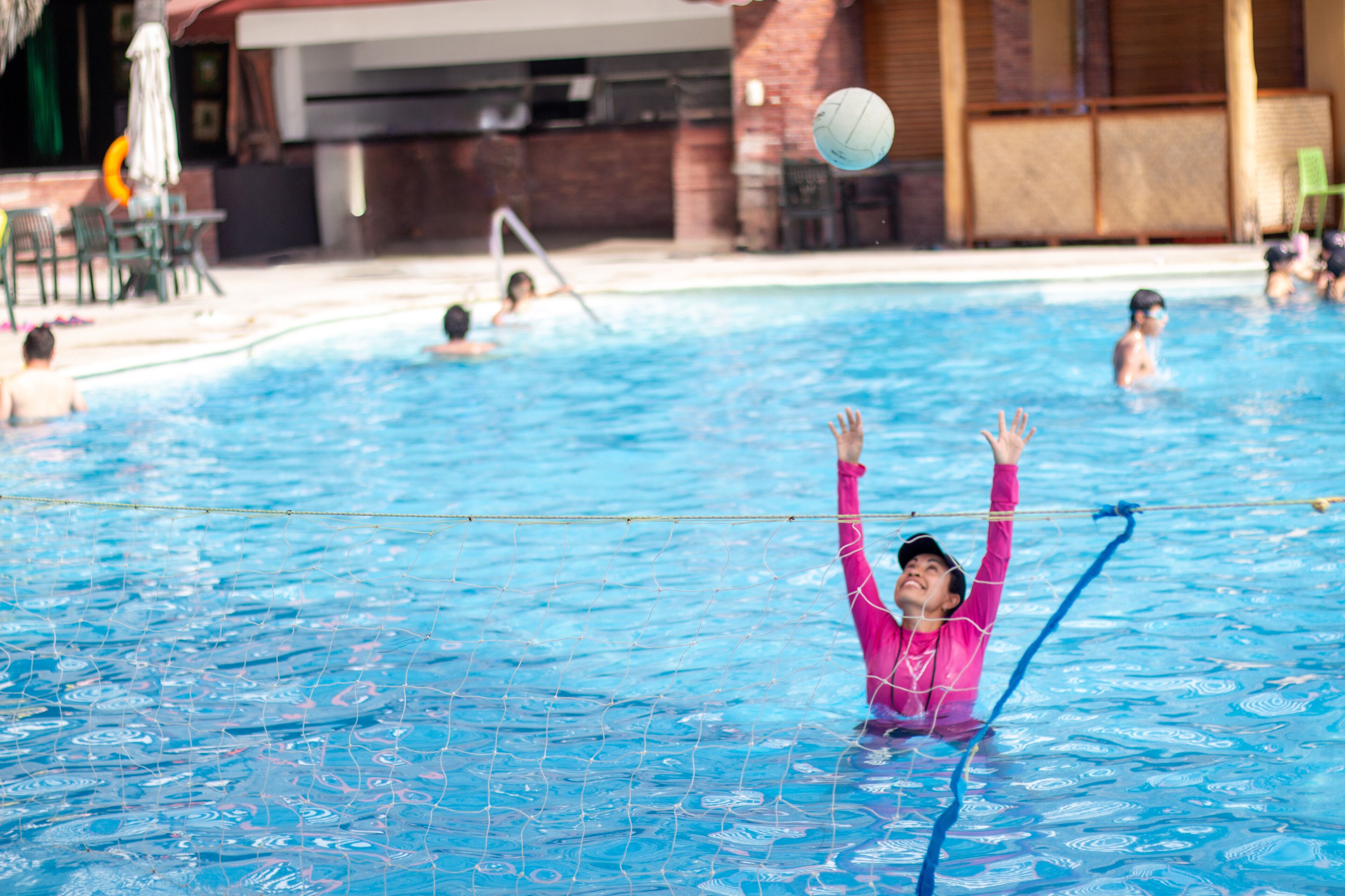 Ein Schwimmbecken mit Personen, die Volleyball spielen.