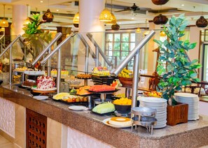A buffet with various food items and a decorative plant. - Dar Es Salaam Serena Hotel (Dar es Salaam)
