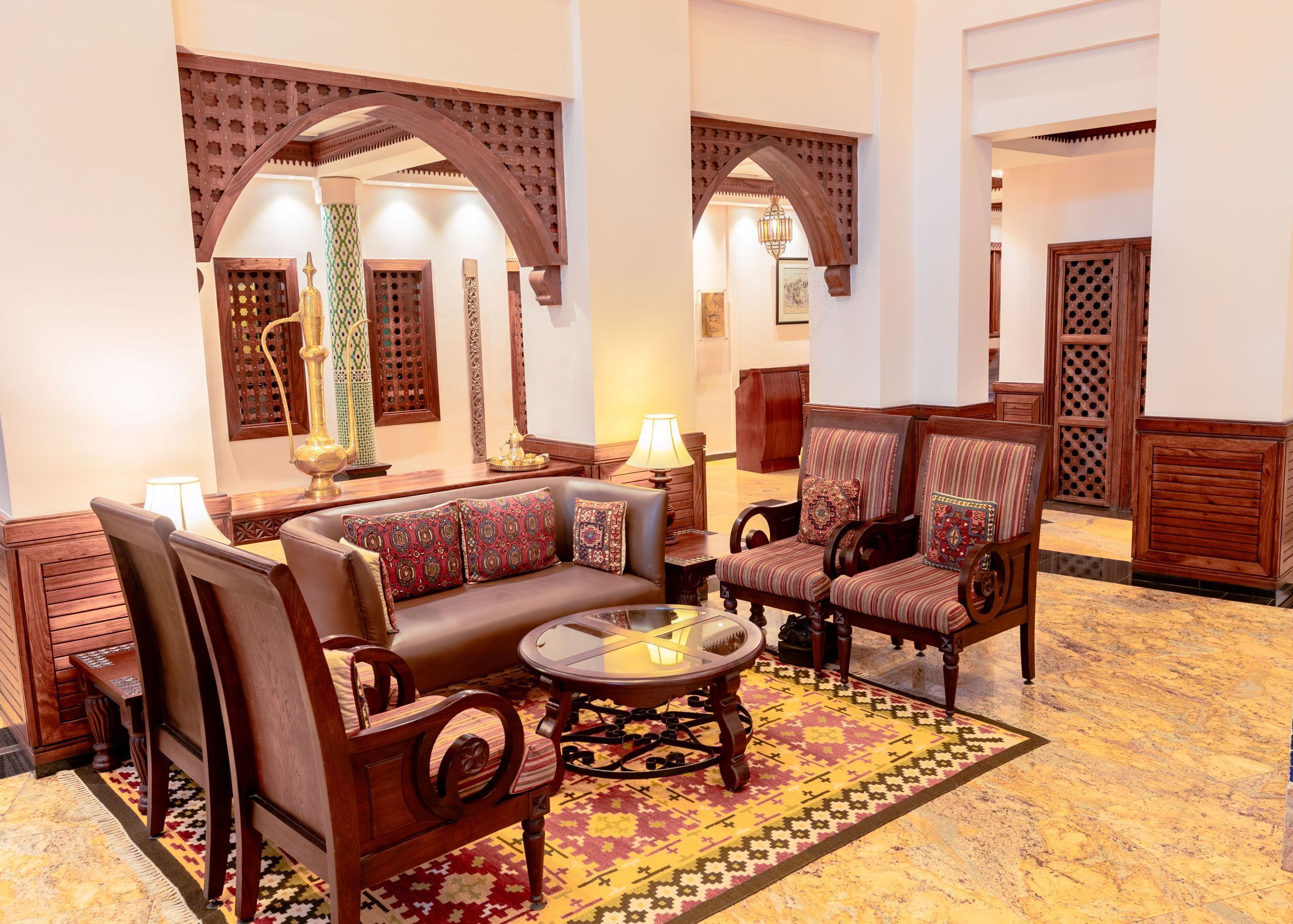 A traditional interior with a sofa, chairs, a coffee table, and patterned rugs.