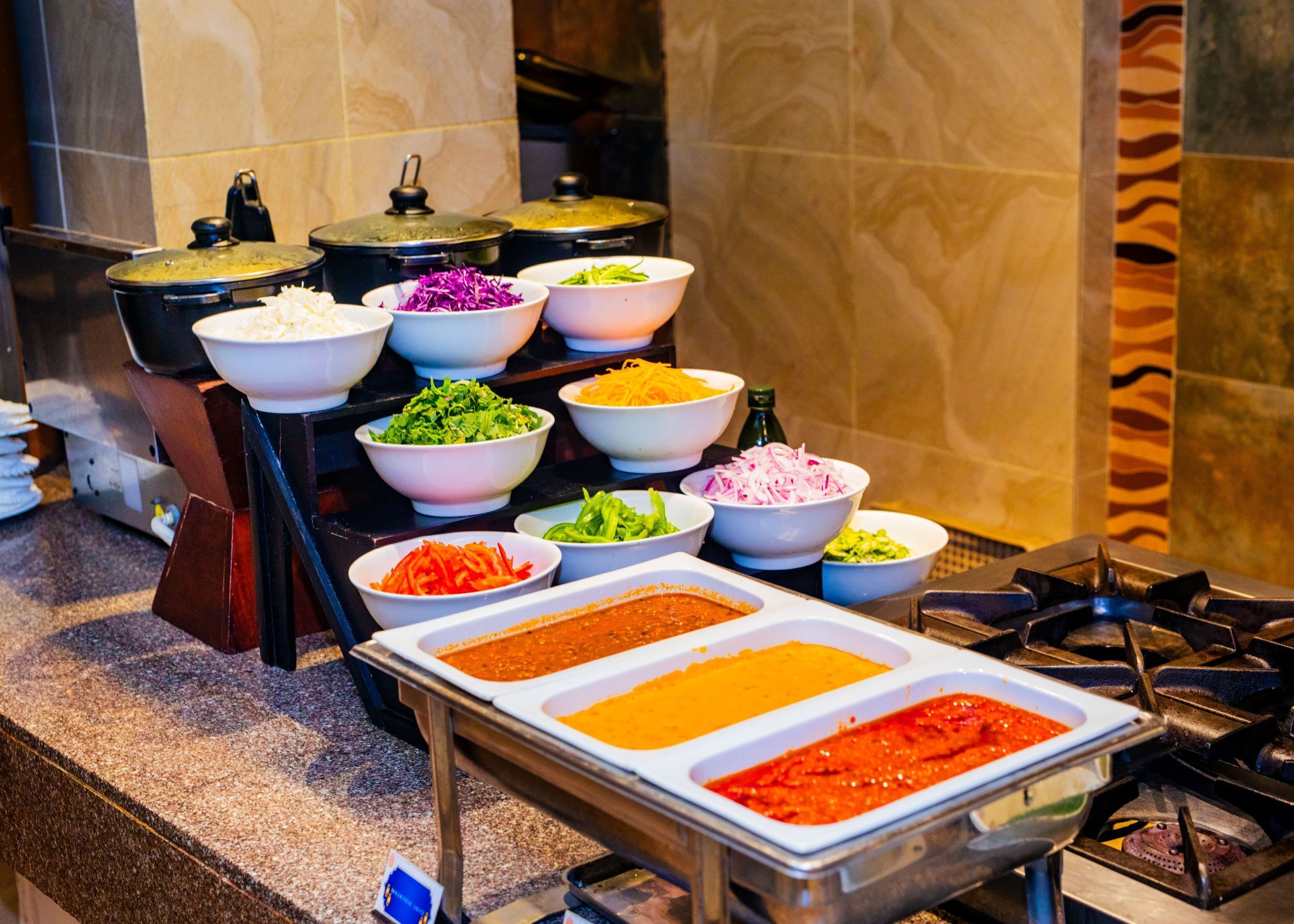 A buffet with various food items and condiments.