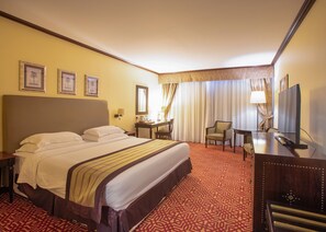 Relax in this inviting room with a large bed, desk, and television.