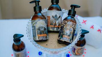 A table with three bottles of body oil and one smaller bottle, surrounded by decorative beads.