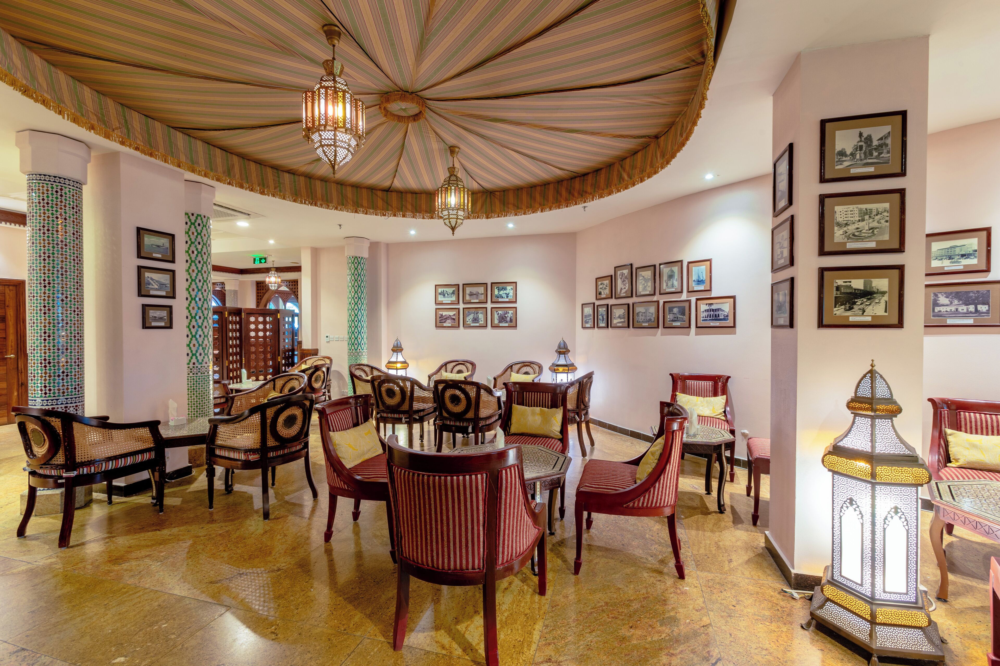 Un comedor con una mesa redonda, sillas y un farol decorativo.