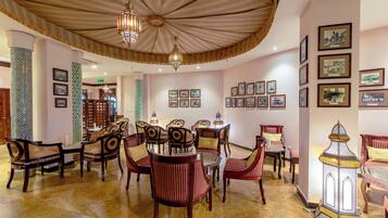 Un comedor con una mesa redonda, sillas y un farol decorativo.