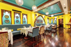 Dine in style with tables set for a comfortable meal, surrounded by artwork and decorative designs.