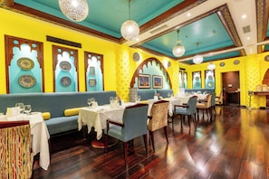 Dine in style with tables set for a comfortable meal, surrounded by artwork and decorative designs.