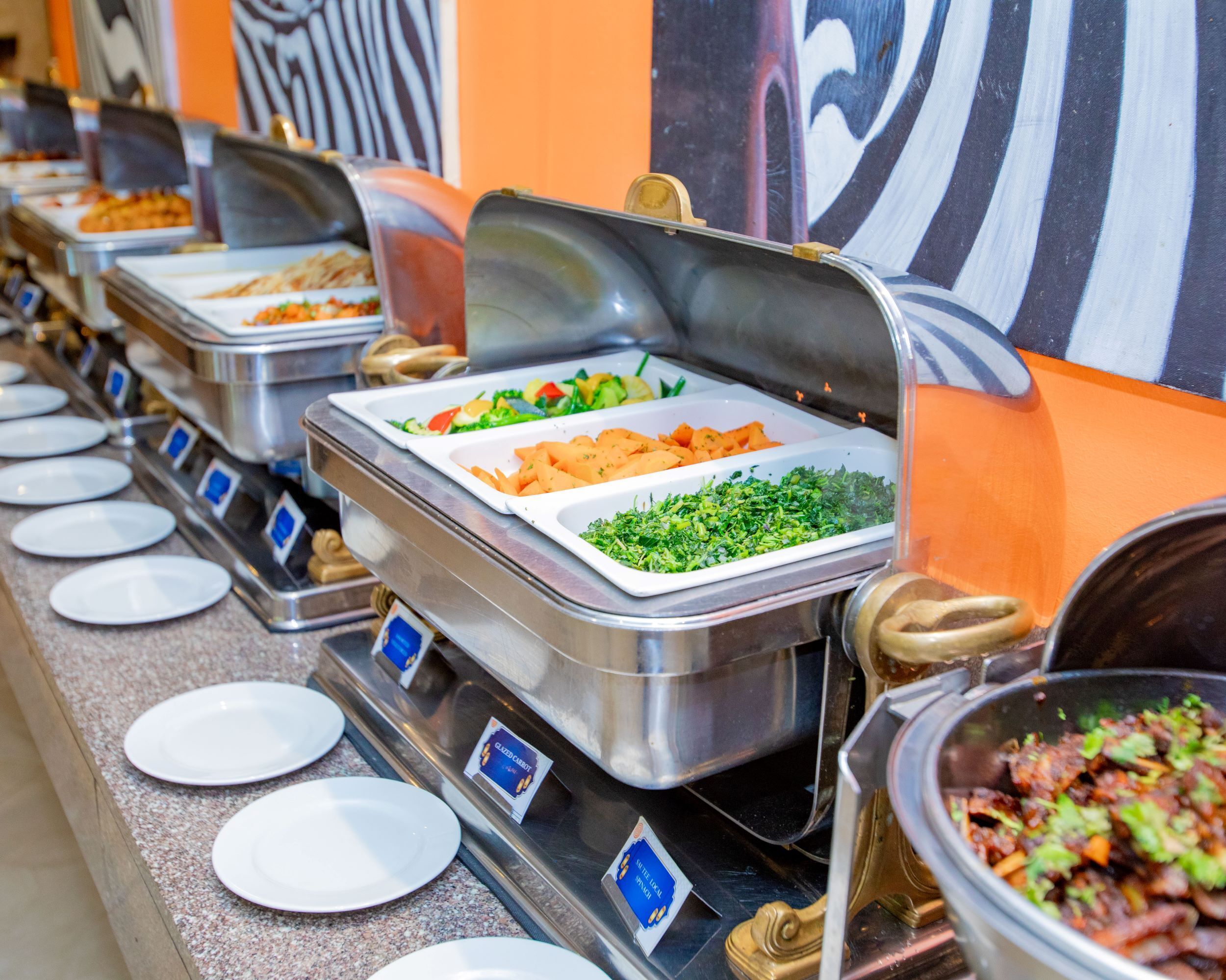 Un buffet proposant une variété de plats, notamment des salades, des légumes et des viandes.