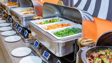 A buffet with various food options, including salads, vegetables, and meats.
