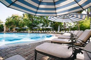 Relax by the pool surrounded by comfortable lounge chairs and lush greenery.