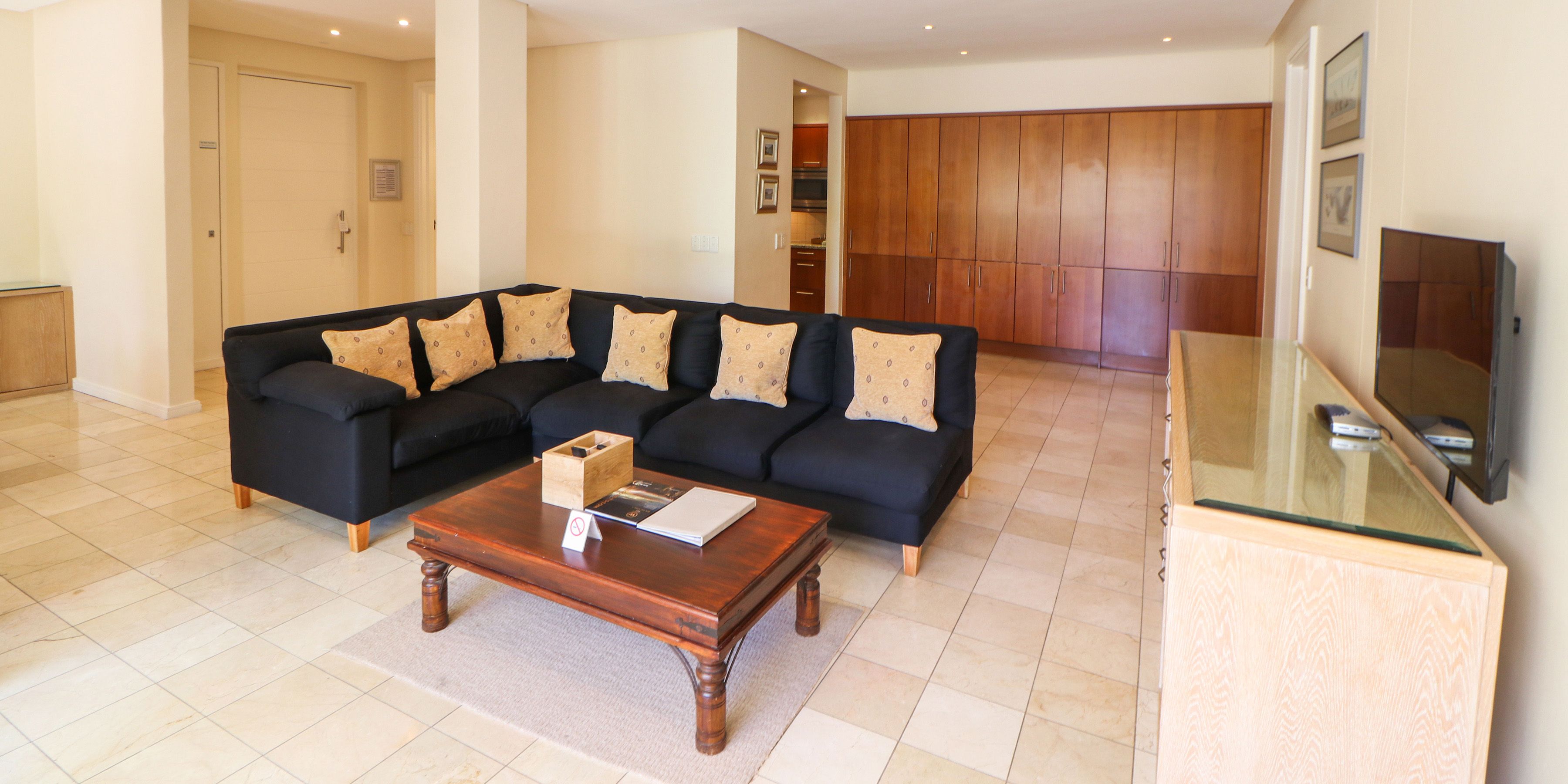 A living room with a sectional sofa, a coffee table, and a glass-top side table.