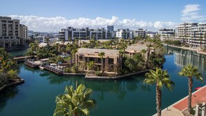 A waterfront hotel with multiple buildings, a marina, and palm trees. - Waterfront Village (Cape Town)