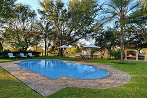 Una piscina al aire libre, sillones reclinables de piscina