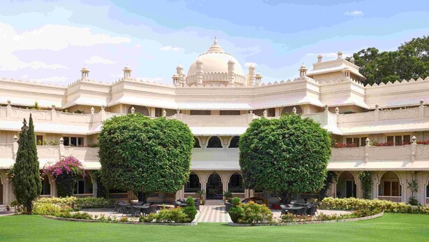 A large, ornate building with a central dome and multiple smaller domes, surrounded by well-manicured gardens and seating areas. - Gateway Aurangabad - Chhatrapati Sambhaji Nagar (Chhatrapati Sambhajinagar)