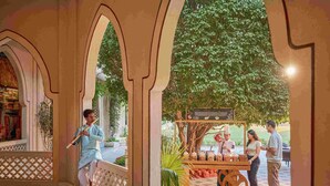 A traditional Indian setting with a musician playing a flute, a food cart, and a couple conversing. - Gateway Aurangabad - Chhatrapati Sambhaji Nagar (Chhatrapati Sambhajinagar)