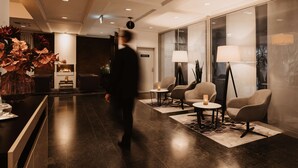 A modern lobby with a reception desk, seating area, and a fireplace.