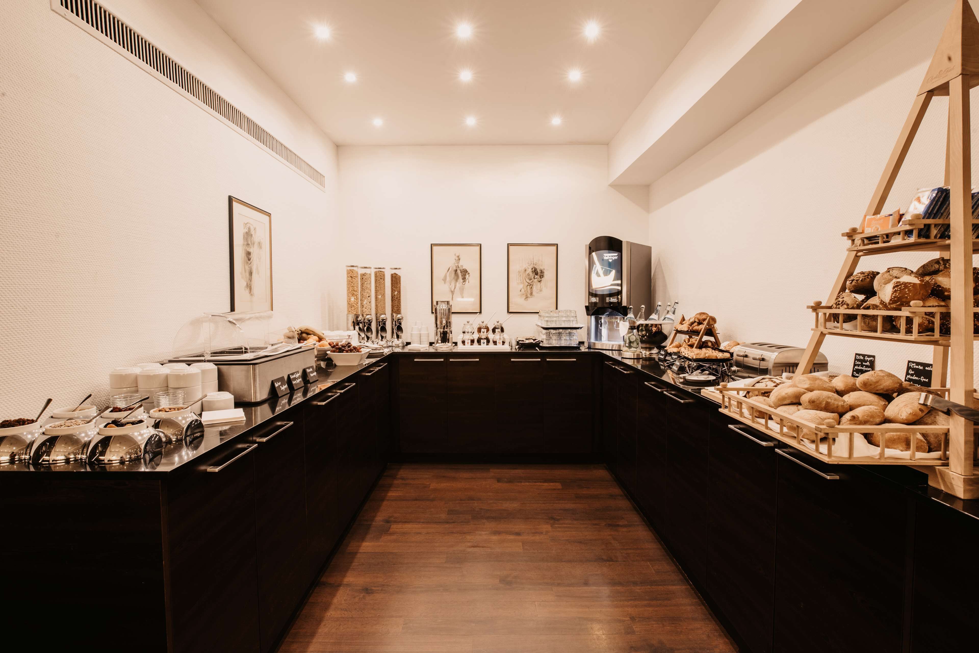 A buffet setup with various food items and a coffee machine.