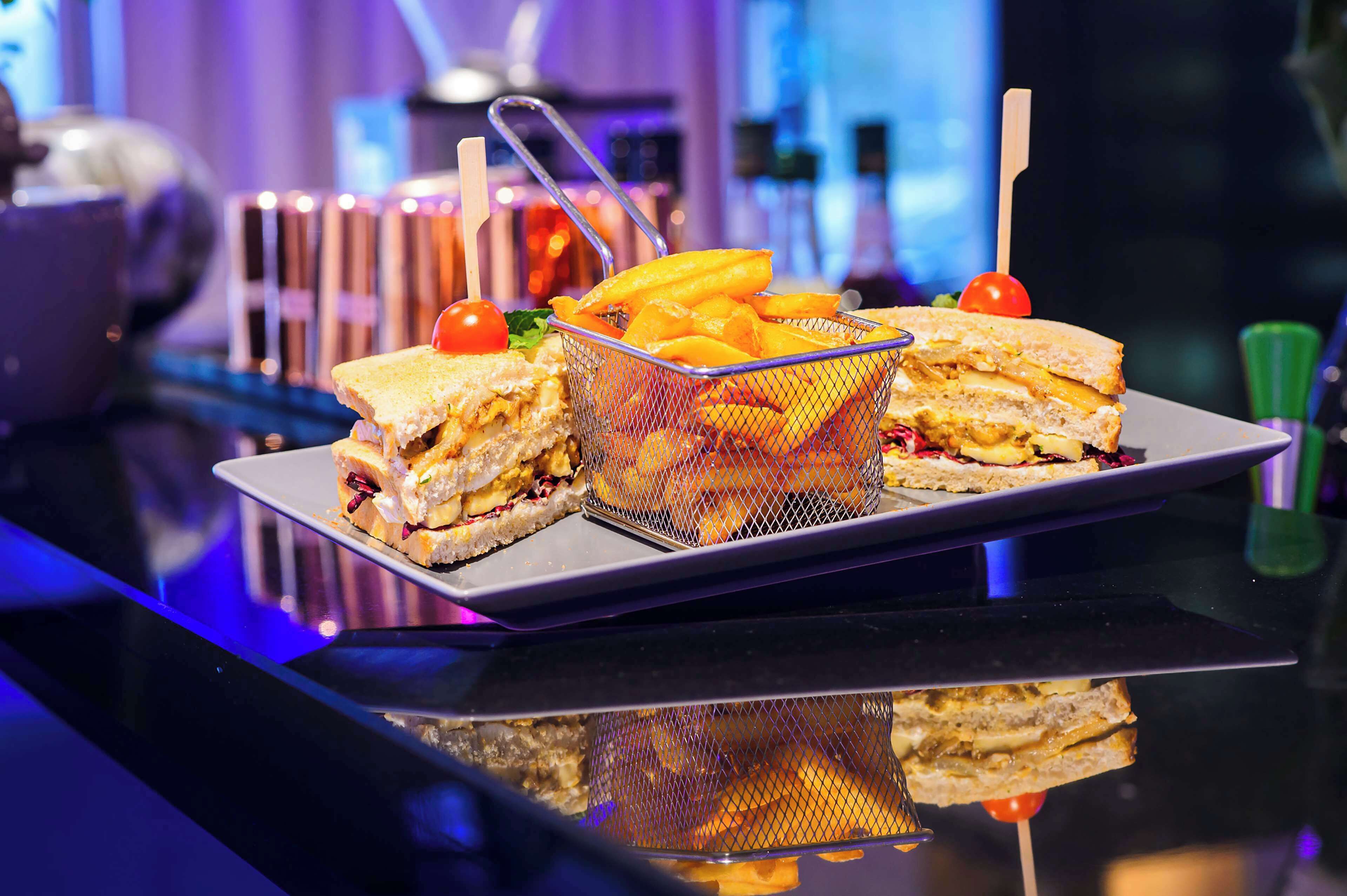 A tray with sandwiches and fries on a reflective surface.