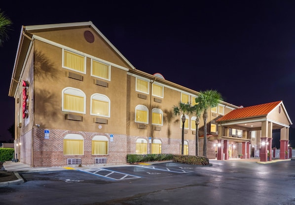 A hotel with a brick facade, multiple windows, and a covered entrance.