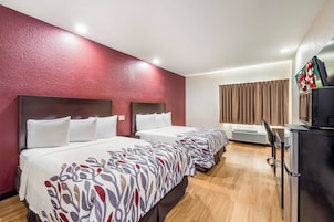 Habitación de hotel con dos camas, televisión y minibar.