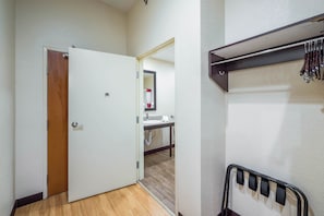A hallway with a wooden floor, a white door, a mirror, and a wall-mounted knife rack.