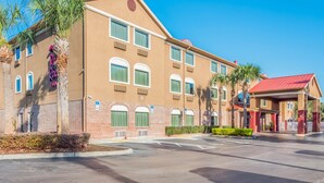 A hotel with a brick facade, multiple windows, and a red-roofed entrance.