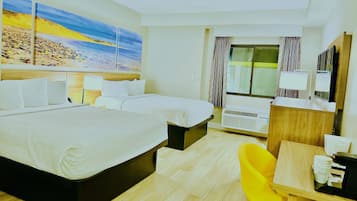 Ein Hotelzimmer mit zwei Betten, einem Schreibtisch mit Stuhl, einem großen Fenster mit Vorhängen und einem Bild mit Strandmotiv.