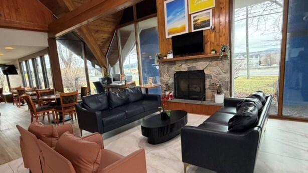 Ein geräumiger Wohnbereich mit Kamin, Ledersofas und einem Essbereich mit Holmöbeln.