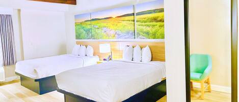 A hotel room with two beds, a green chair, and a large landscape painting on the wall.