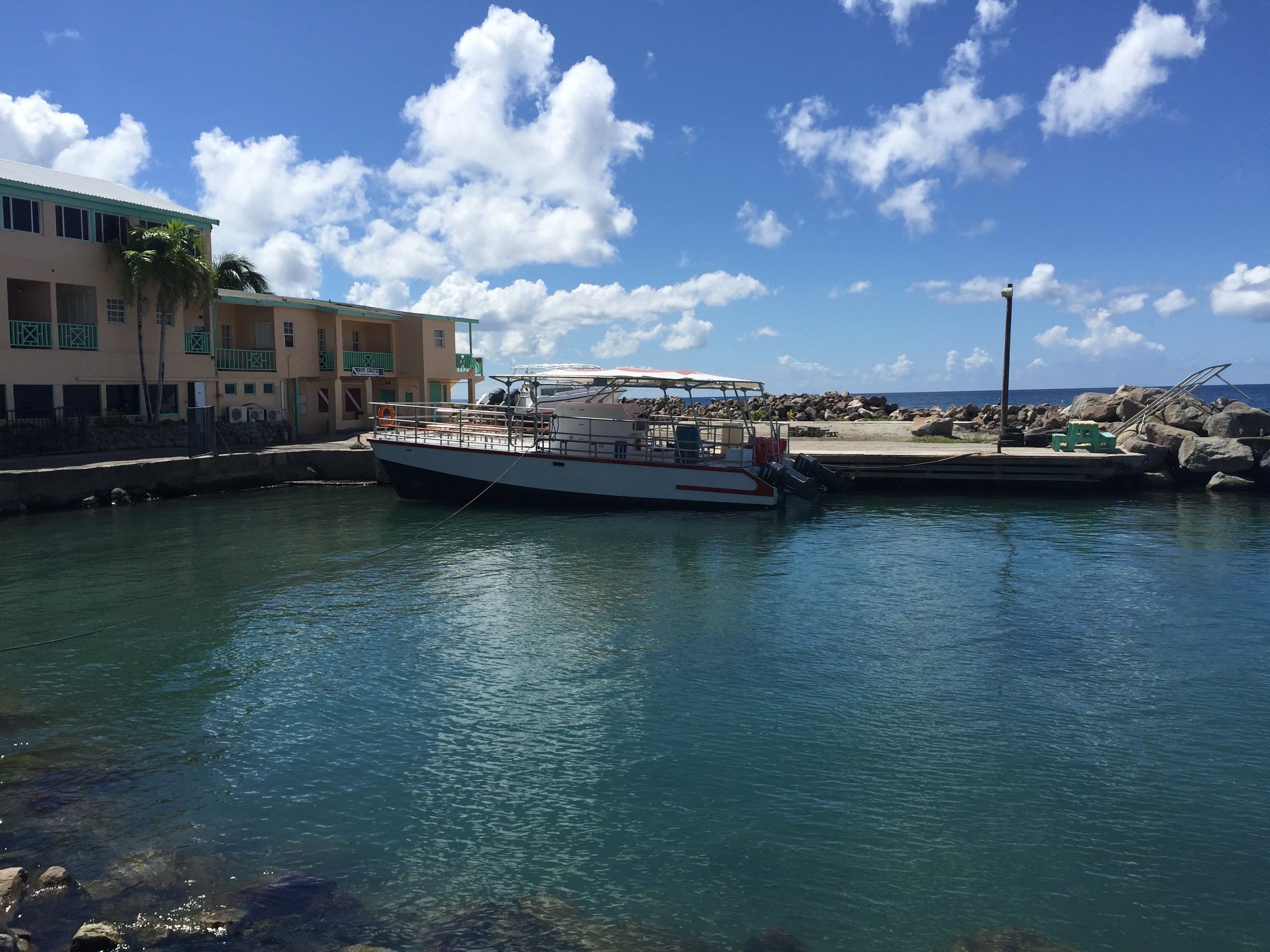 Un bateau était amarré dans une marina, sous un ciel dégagé et sur une eau calme.