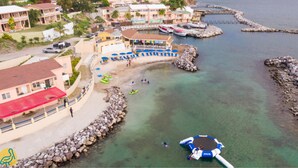 A coastal area with a beach, boats, and a floating platform. - Bird Rock Beach Hotel (Basseterre)