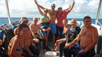 A group of people on a boat with a clear view of the ocean.