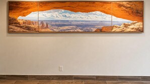 Una amplia pintura de paisaje sobre una pared.