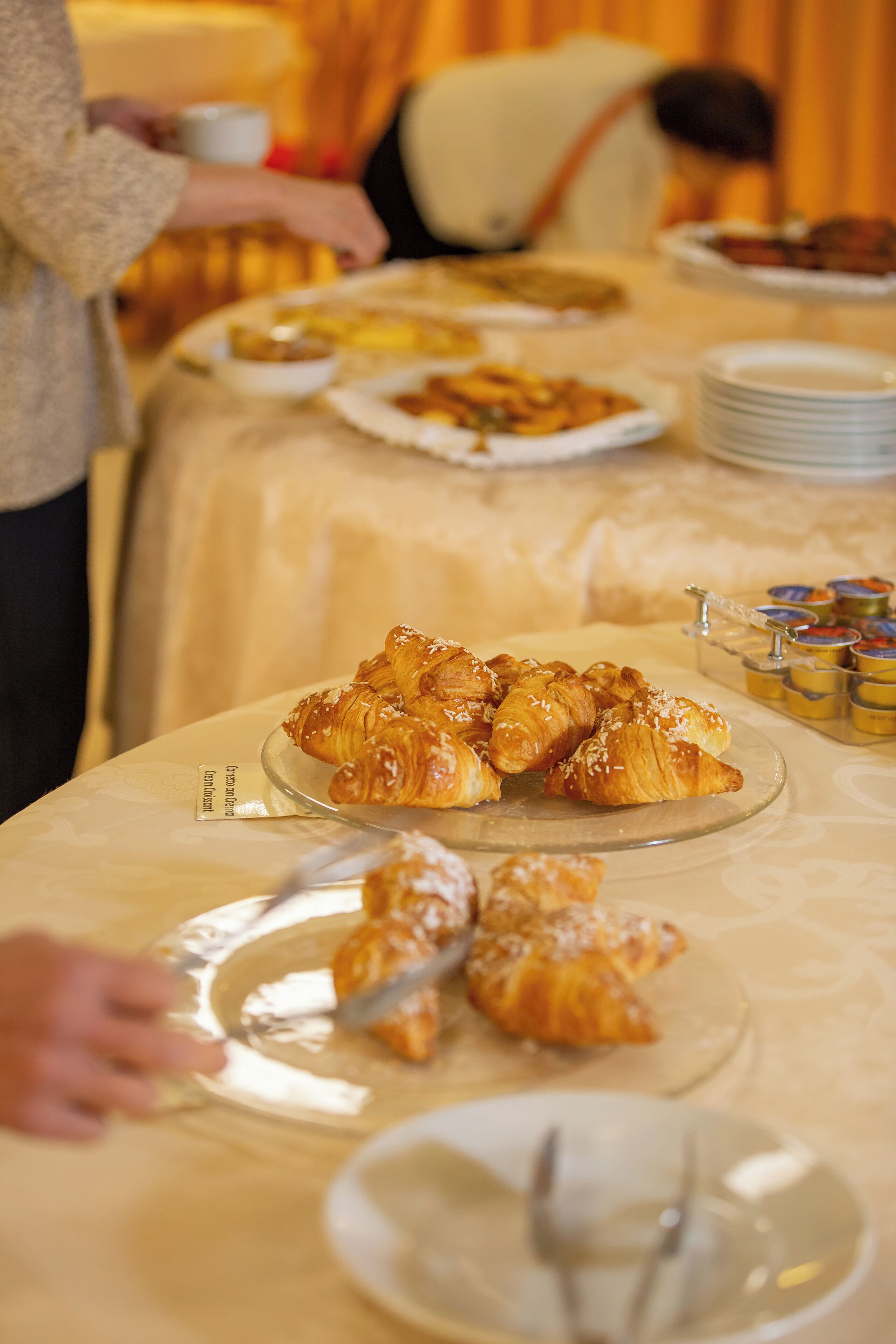 A buffet table with various food items, including pastries and condiments.