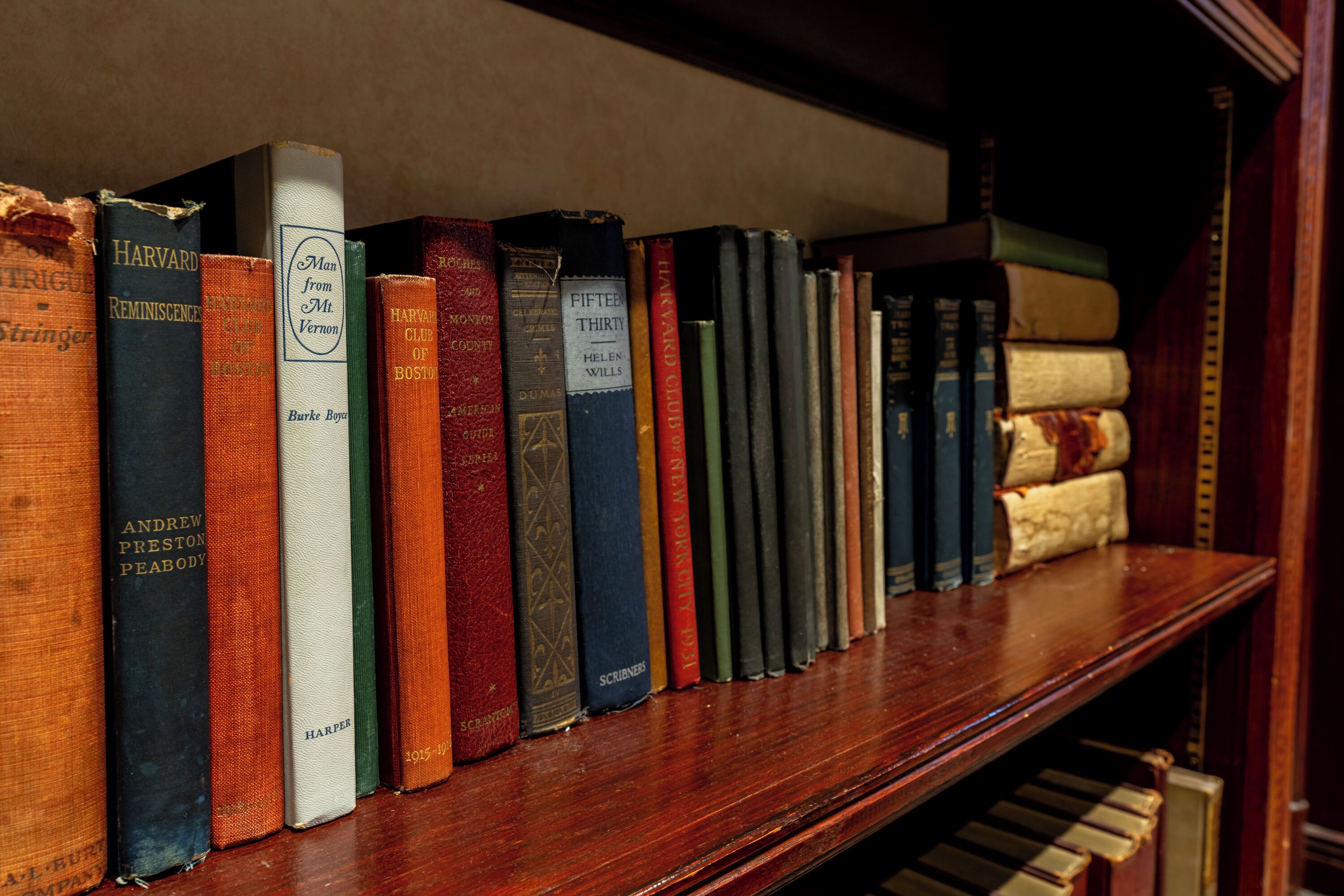 Une bibliothèque en bois contenant une variété de livres à couverture rigide.
