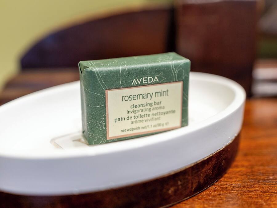 A bar of Aveda rosemary mint cleansing bar on a white plate.