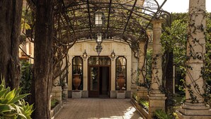 A covered entrance with a wooden door, stone columns, and hanging lanterns. - Grand Hotel Timeo, A Belmond Hotel, Taormina (Taormina)