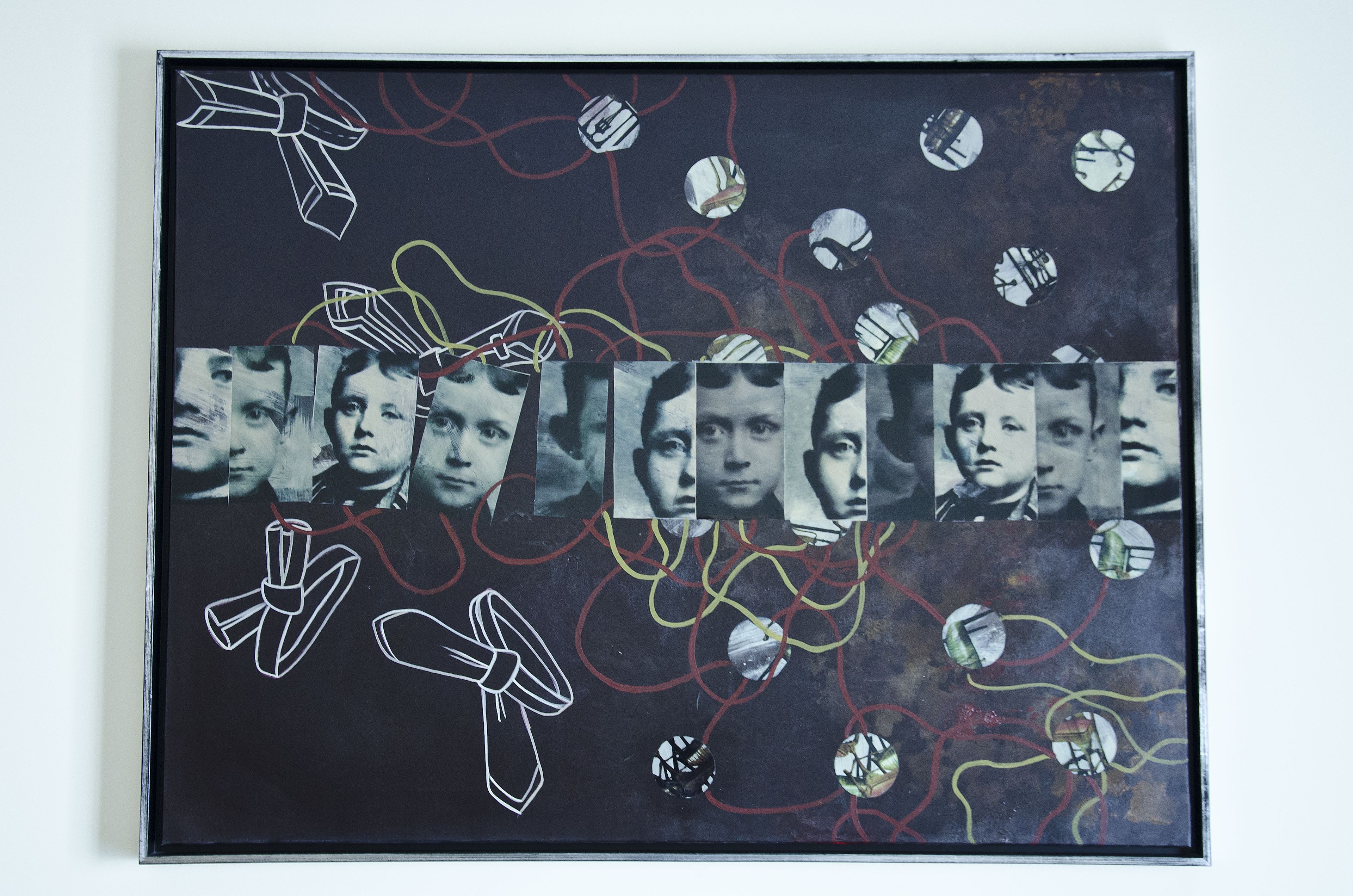 A framed artwork with abstract designs and multiple circular cutouts.