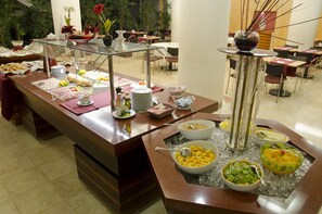 A buffet setup with various food items and a glass display case. - VIP Executive Entrecampos Hotel & Conference (Lisbon)