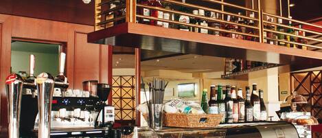 A bar area with a coffee machine, shelves with bottles, and a buffet counter.