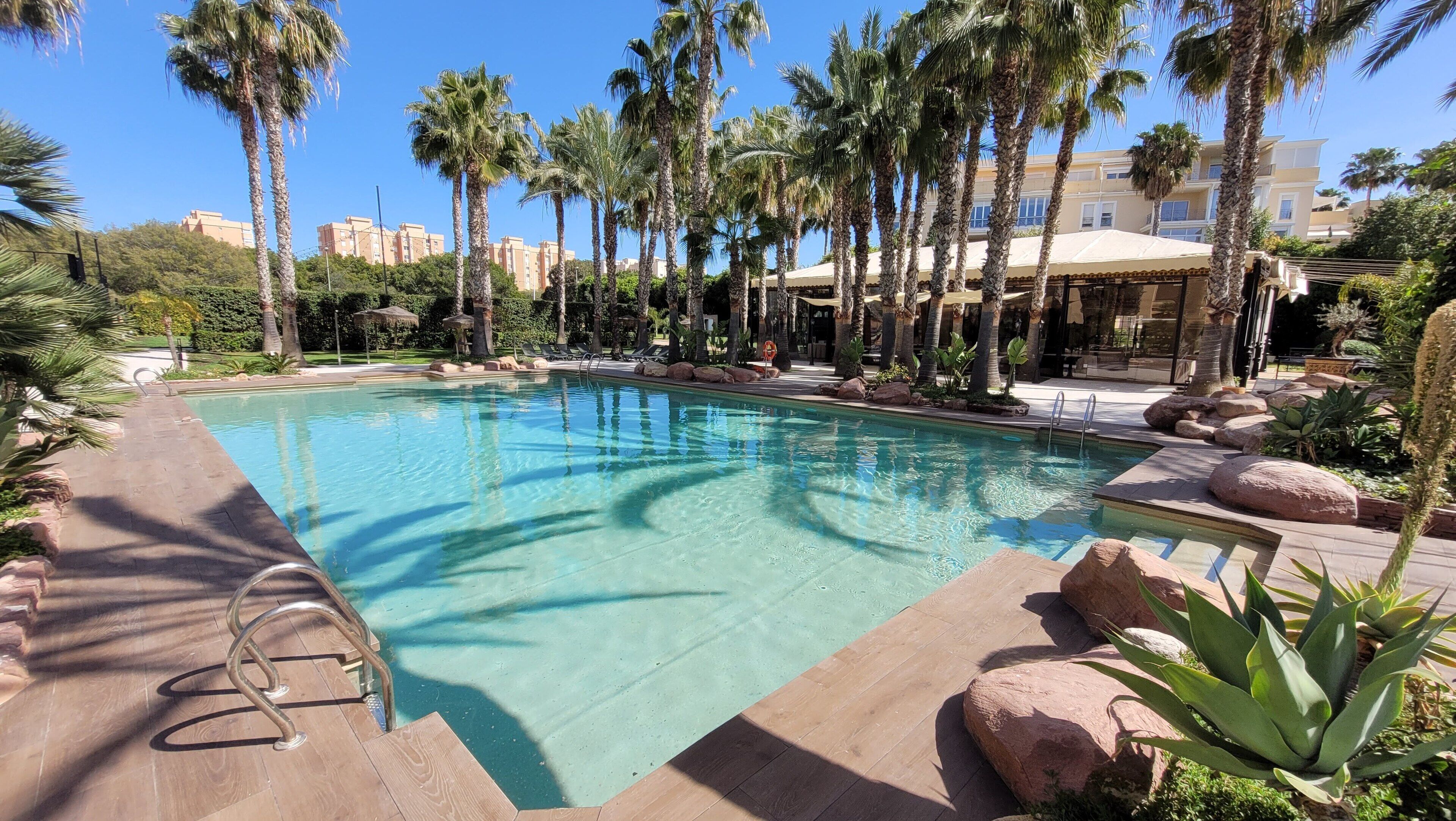 Una piscina al aire libre de temporada, sombrillas