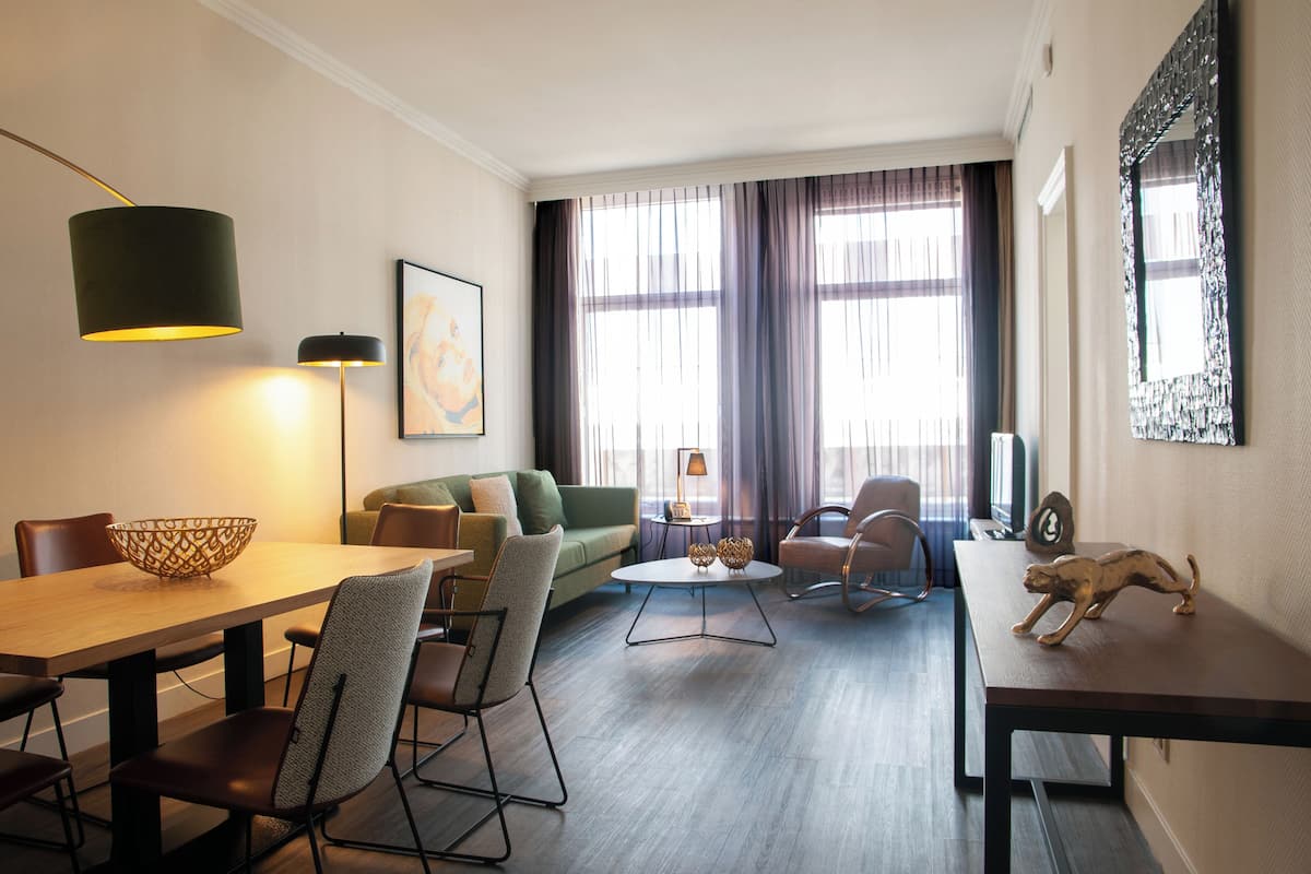 Un salon moderne comprenant un coin repas, un canapé, une table basse et une lampe.