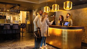 Een hotel receptie met een bar en zitplaatsen.