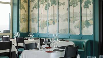 Un restaurante con mesas dispuestas para comer, sillas y un gran mural en la pared.