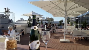 A rooftop terrace with outdoor seating, a bottle of cava, and a glass of wine. - Cinema Hotel - an Atlas Boutique Hotel (Tel Aviv)