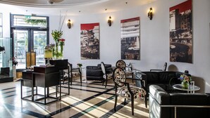 Un vestíbulo con piso a cuadros, sofás de cuero negro y una mesa de recepción.