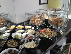 Un buffet proposant une variété de plats et d’ustensiles.