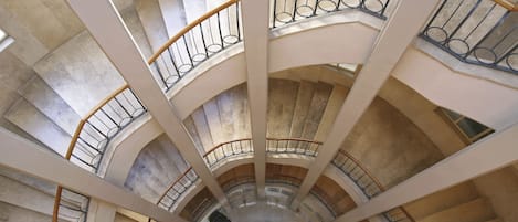 A multi-level atrium with curved staircases and metal railings.