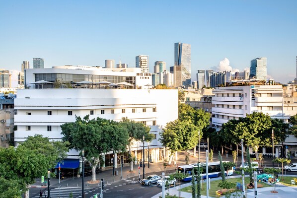 A modern hotel with a flat facade, large windows, and a rooftop terrace.