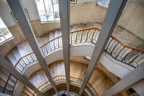 A multi-level interior with a central staircase surrounded by balconies. - Cinema Hotel - an Atlas Boutique Hotel (Tel Aviv)